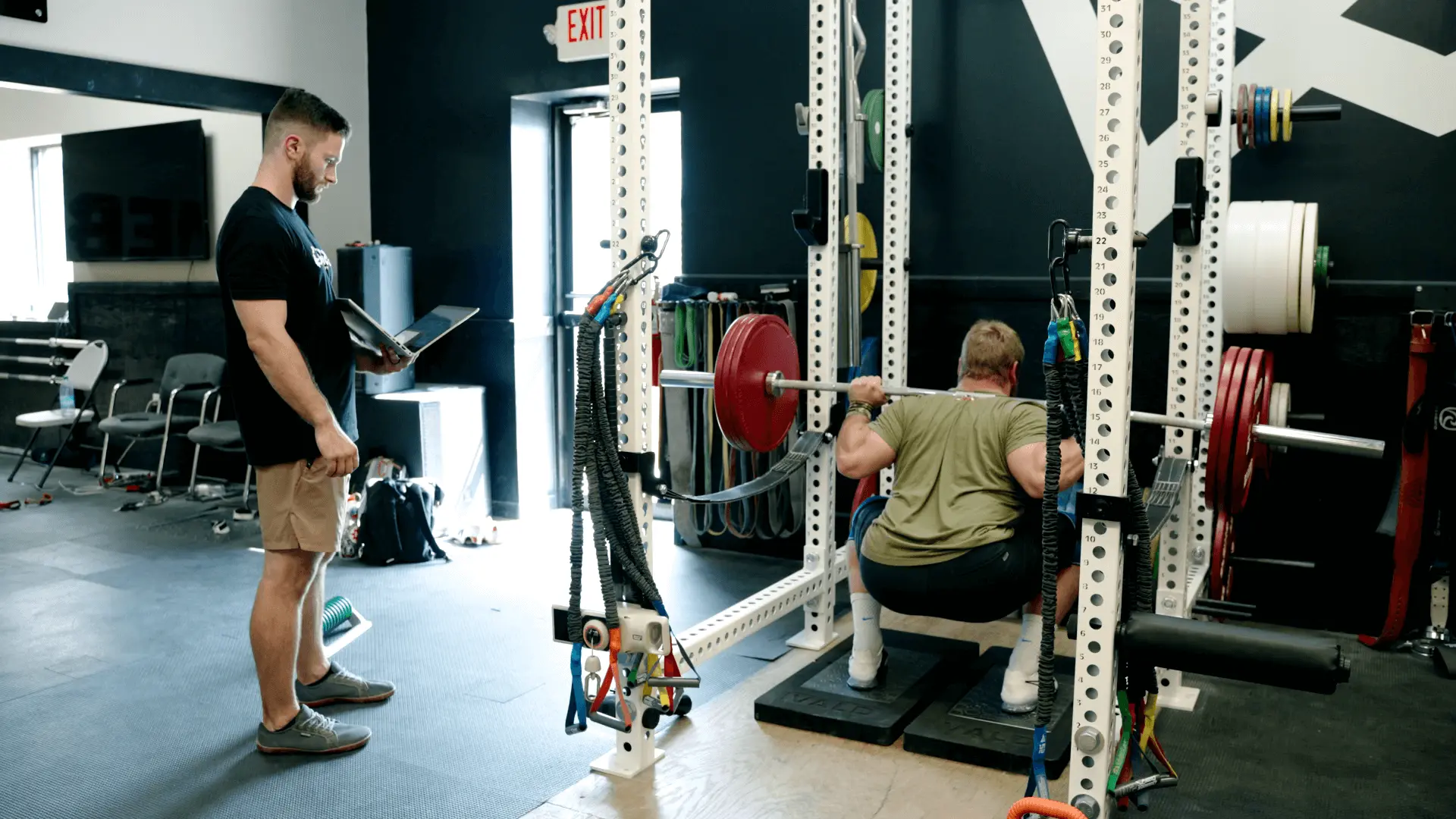 Olympian Wes Kitts performing a loaded squat assessment on ForceDecks with Physical Therapist Jake Lohr monitoring his live feedback on the computer.